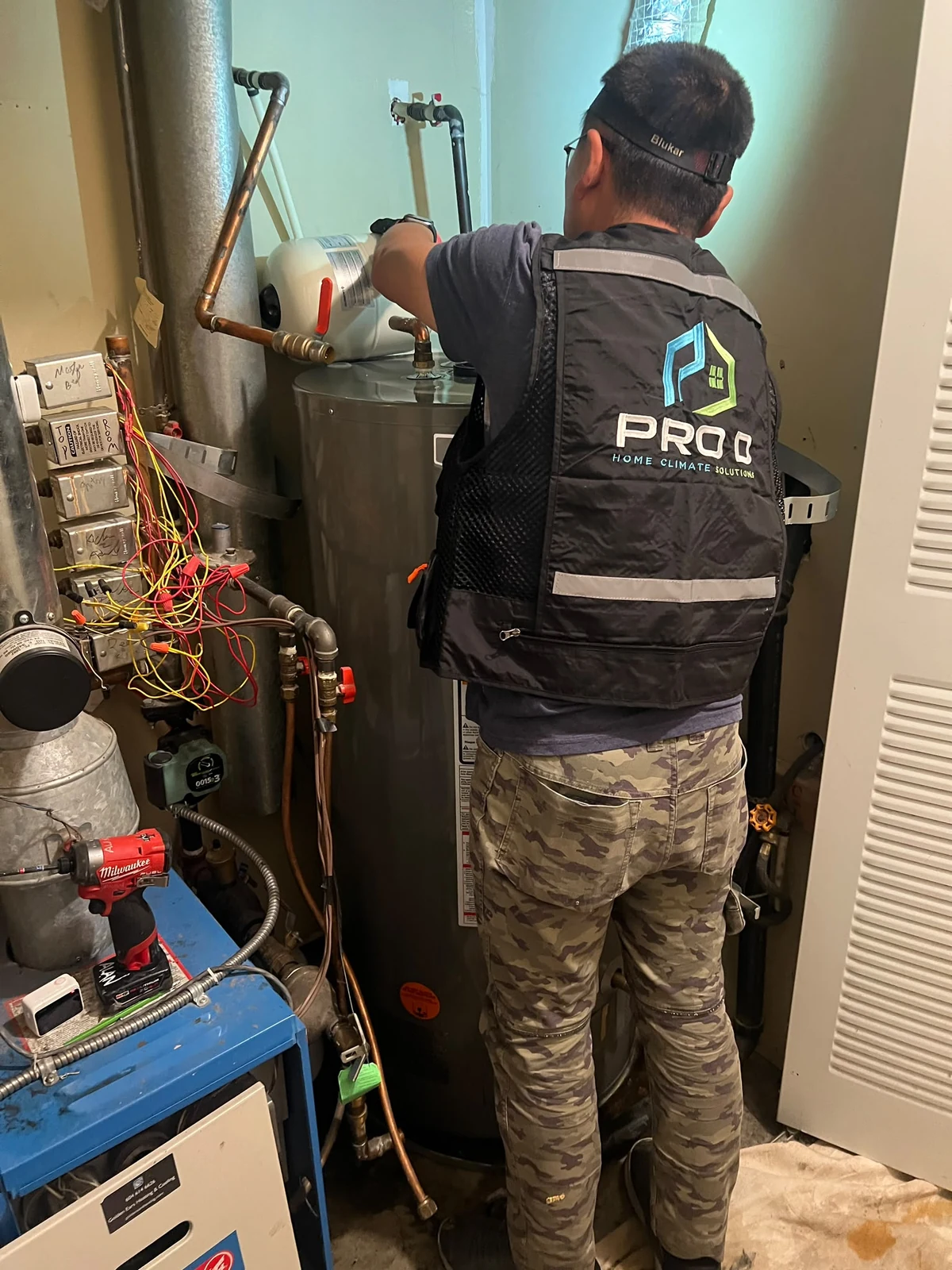 Technician working on the tank water heater in the Langley rental home project