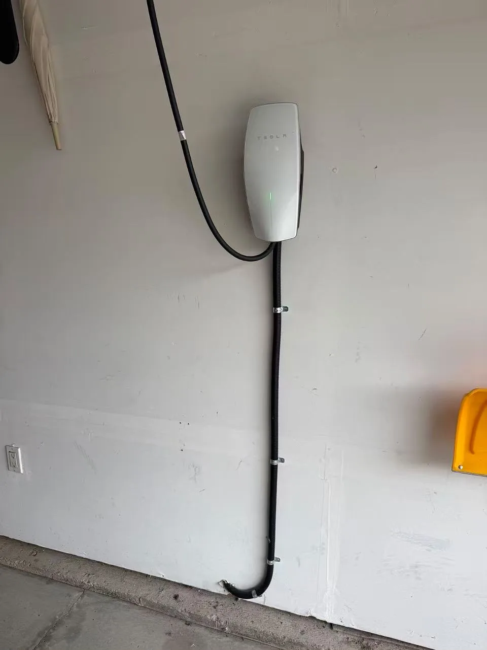 Tesla home charger installed on a garage wall